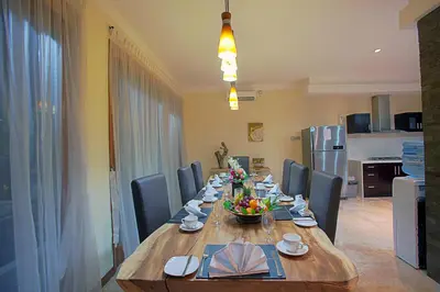 a dining room table with chairs and a long wooden table at O Villas Seminyak in Seminyak