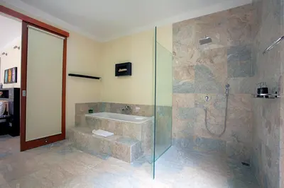 a bathroom with a shower and a tub and a sink at O Villas Seminyak in Seminyak