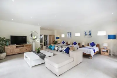 a living room with a couch and a tv at Villa Marronniers in Seminyak