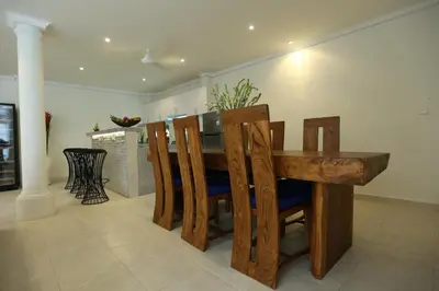 a dining room with a wooden table and chairs at Villa Marronniers in Seminyak