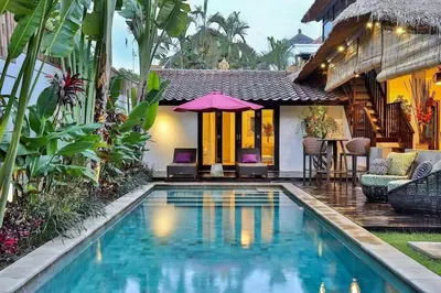 a swimming pool in front of a house at Villa Champagne in Seminyak