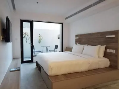 a bedroom with a large bed and a table at Lloyd's Inn Bali in Seminyak