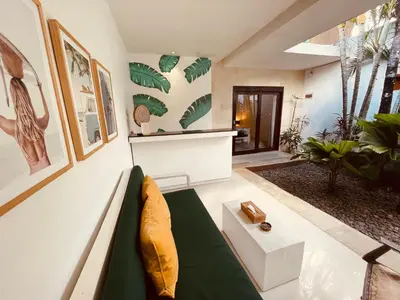 a living room with a couch and some plants at La Belle Villa in Seminyak