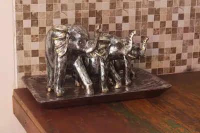 a bronze statue of a group of elephants on a shelf at Jukung Villas Kuta in Kuta