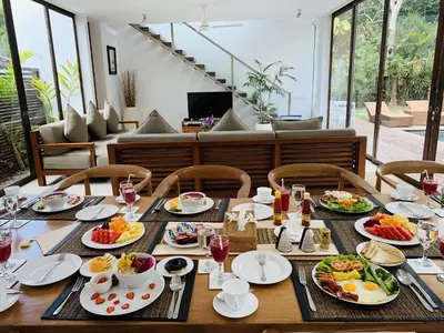 a table with plates of food on it at Beach Axis Villa, Seminyak in Seminyak