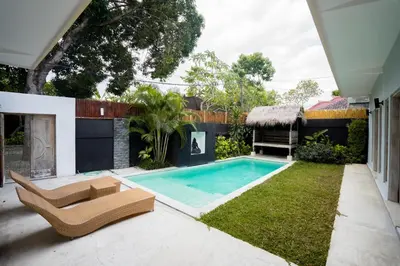 a swimming pool in the backyard of a house at The Catur Villa Seminyak in Seminyak
