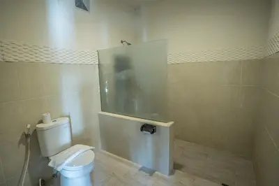 a bathroom with a white toilet in a room at The Catur Villa Seminyak in Seminyak