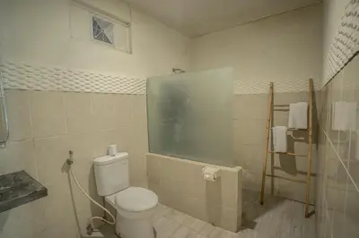 a bathroom with a toilet and a window at The Catur Villa Seminyak in Seminyak