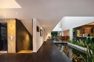 a hallway of a house with a fish pond at The Akmani Legian in Legian