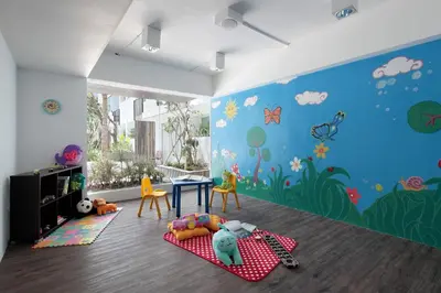 a childrens room with a blue wall with animals and a table at The Akmani Legian in Legian
