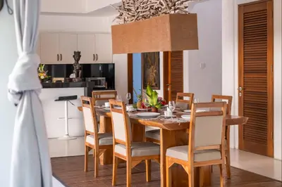 a kitchen and dining room with a wooden table and chairs at Villa Lagoon Canggu in Canggu