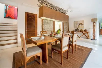 a dining room with a wooden table and chairs at Villa Lagoon Canggu in Canggu