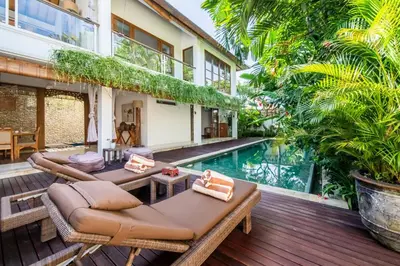 an outdoor patio with a swimming pool and a villa at Villa Lagoon Canggu in Canggu