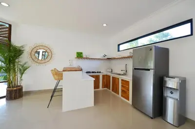 a kitchen with a stainless steel refrigerator and wooden cabinets at Villa Zenta in Canggu