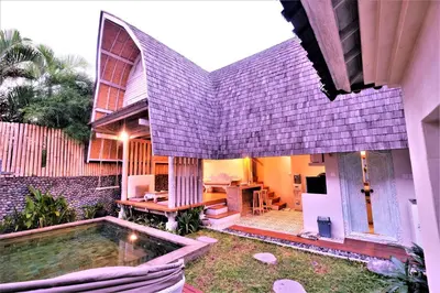 a house with a swimming pool in the yard at Villa Made West in Seminyak
