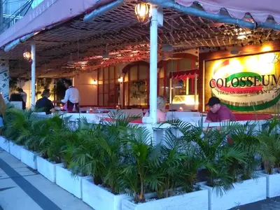 people sitting at tables outside of a restaurant at Villa Made West in Seminyak