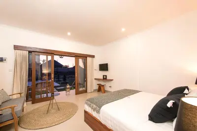 a bedroom with a bed and a balcony at Puri Uma Ratu by RPM in Seminyak