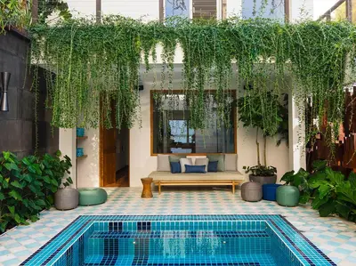 a patio with a pool and a bench and plants at Noku Beach House by Elite Havens in Seminyak