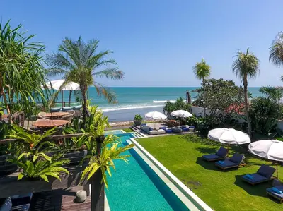 a resort with a swimming pool and the ocean at Noku Beach House by Elite Havens in Seminyak