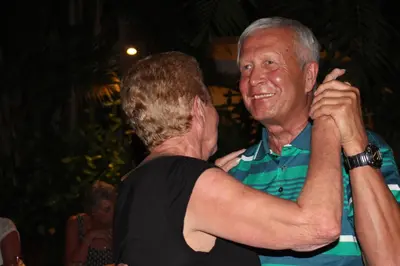 an older man is hugging another man at Sarinande Hotel in Seminyak