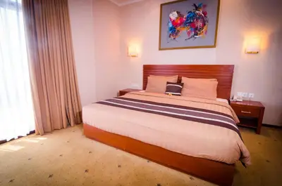 a bedroom with a bed with a laptop on it at Bali Paradise City Hotel in Denpasar