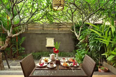 a table with food on it with two chairs at Nyuh Bali Villas in Seminyak
