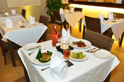 a table with plates of food and wine on it at Nyuh Bali Villas in Seminyak