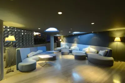 a waiting room with couches and tables and lights at IZE Seminyak by LifestyleRetreats in Seminyak