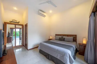 a bedroom with a bed and a television in it at Amandaru Villa by RPM in Legian