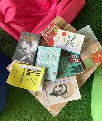 a pile of books sitting on the grass at Beach Hut Hostel in Kuta