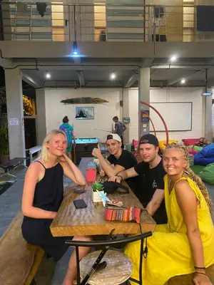 a group of people sitting at a table at Beach Hut Hostel in Kuta