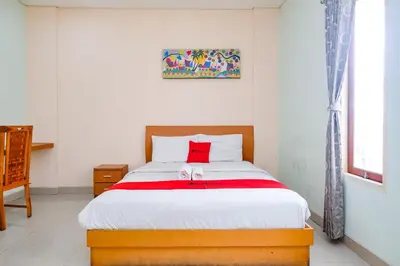 a bedroom with a bed with a red pillow on it at RedDoorz Plus @ Mahendradatta Denpasar in Denpasar