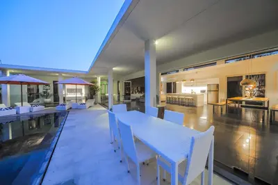 a dining room with a table and chairs on a patio at Casa Priya Petitenget in Seminyak