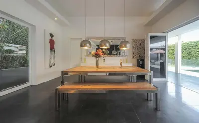 a room with a table with a vase of flowers on it at Casa Priya Petitenget in Seminyak