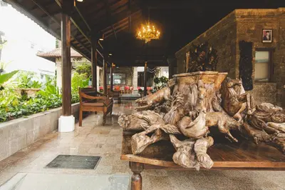 a wooden bench sitting in front of a restaurant at Sari Bunga Hotel Legian Kuta Bali in Legian