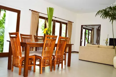 a dining table and chairs in a living room at Seminyak Villa Lumina in Seminyak