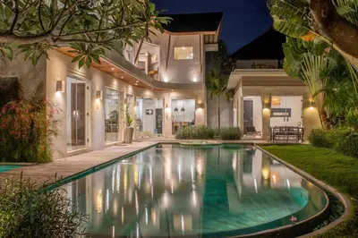a swimming pool in front of a house at night at Villa K-Mea in Seminyak