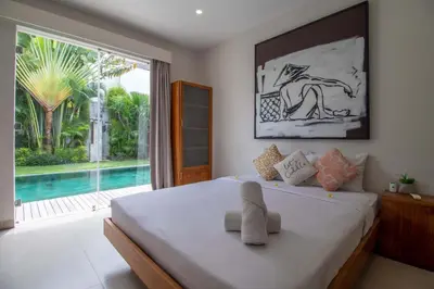 a bedroom with a bed with a view of a pool at Villa K-Mea in Seminyak