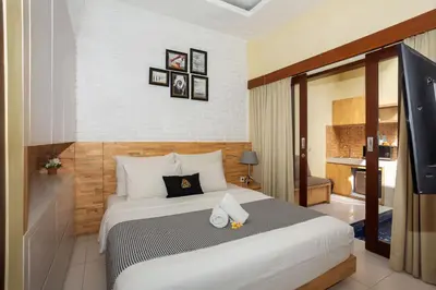 a bedroom with a large bed in a room at Paisa Seminyak Living in Seminyak