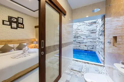 a bathroom with a tub and a shower and a sink at Paisa Seminyak Living in Seminyak