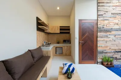 a living room with a couch and a wooden door at Paisa Seminyak Living in Seminyak