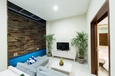 a living room with a couch and a tv at Paisa Seminyak Living in Seminyak