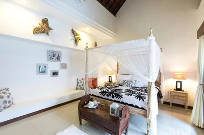 a bedroom with a bed with a canopy at Villa Kamboja Five in Seminyak