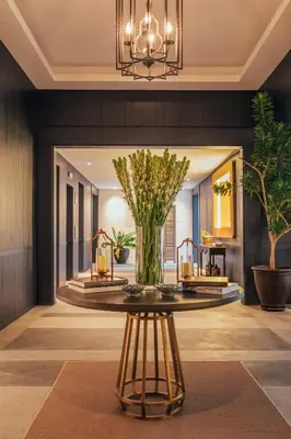 a lobby with a table with a plant on it at Kanvaz Village Resort Seminyak in Seminyak