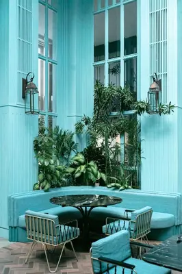 a patio with a table and chairs and plants at Kanvaz Village Resort Seminyak in Seminyak