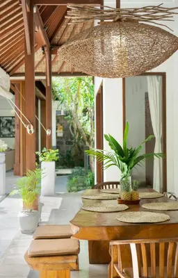 a dining room with a wooden table with chairs at Villa Cinta Umalas in Canggu