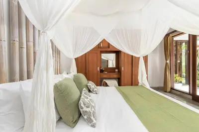 a bedroom with a white bed with a canopy at Villa Cinta Umalas in Canggu