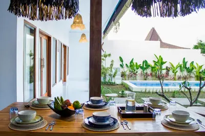 a wooden table with plates of food on it at Villa Orked 2 in Seminyak