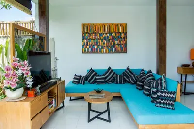 a living room with a blue couch and a tv at Villa Orked 2 in Seminyak