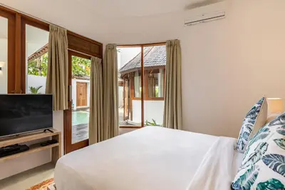 a bedroom with a bed and a flat screen tv at The Lagoon Canggu in Canggu